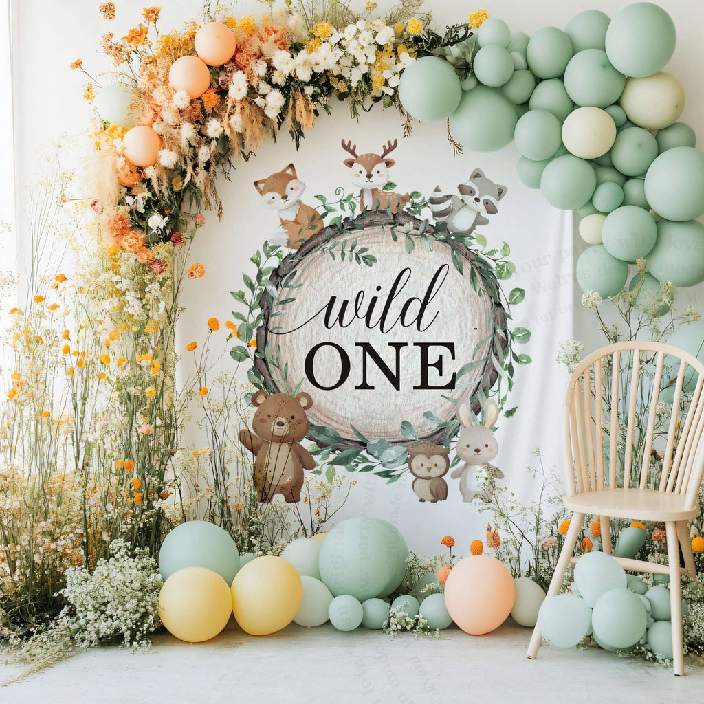 Woodland wild one backdrop with tall wildflowers, mint balloons and a white chair.