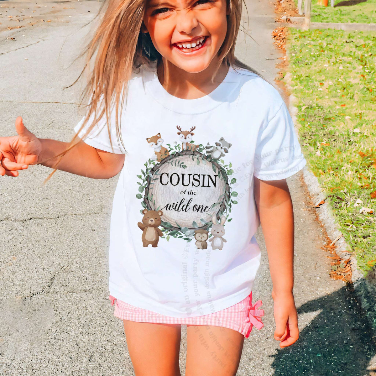 Laughing girl outdoors in a white Cousin of the Wild One kids tee.